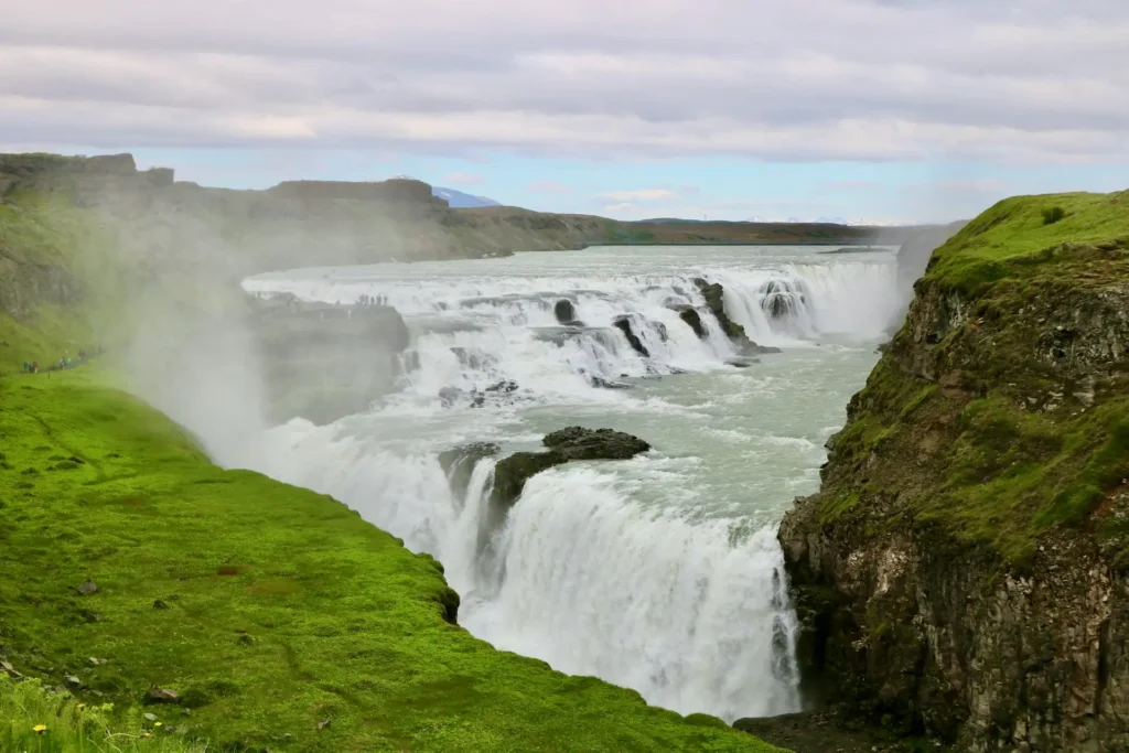 Powerful Icelandic waterfall surrounded by green cliffs