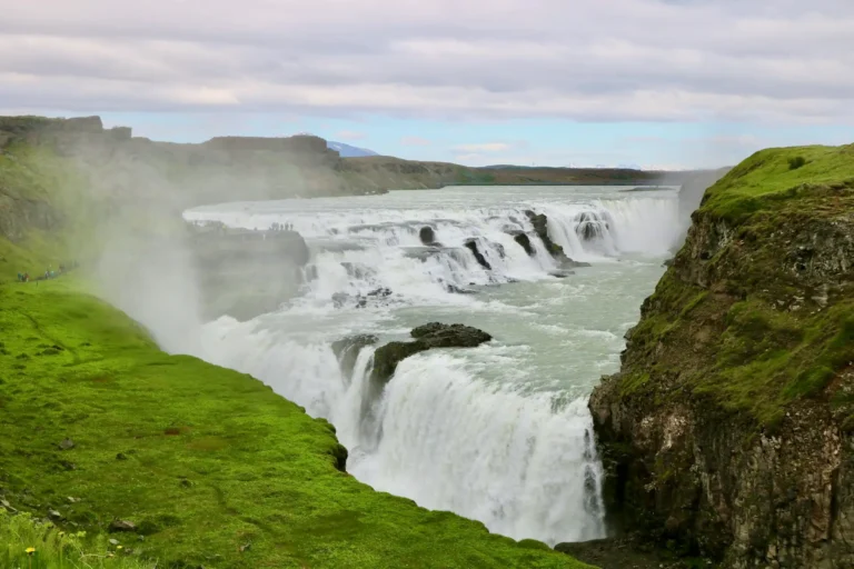 Powerful Icelandic waterfall surrounded by green cliffs