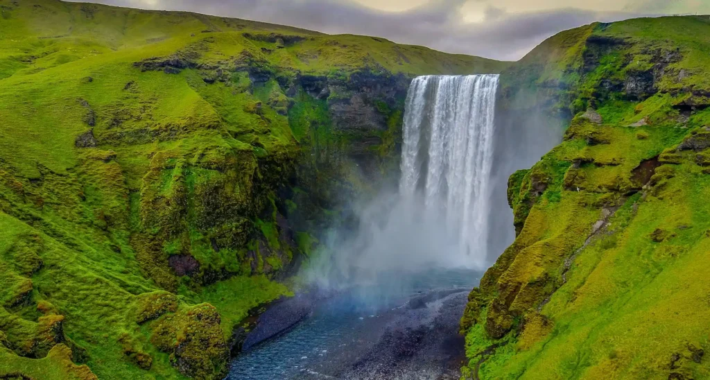 Icelandic waterfall surrounded by lush green cliffs on the South Coast